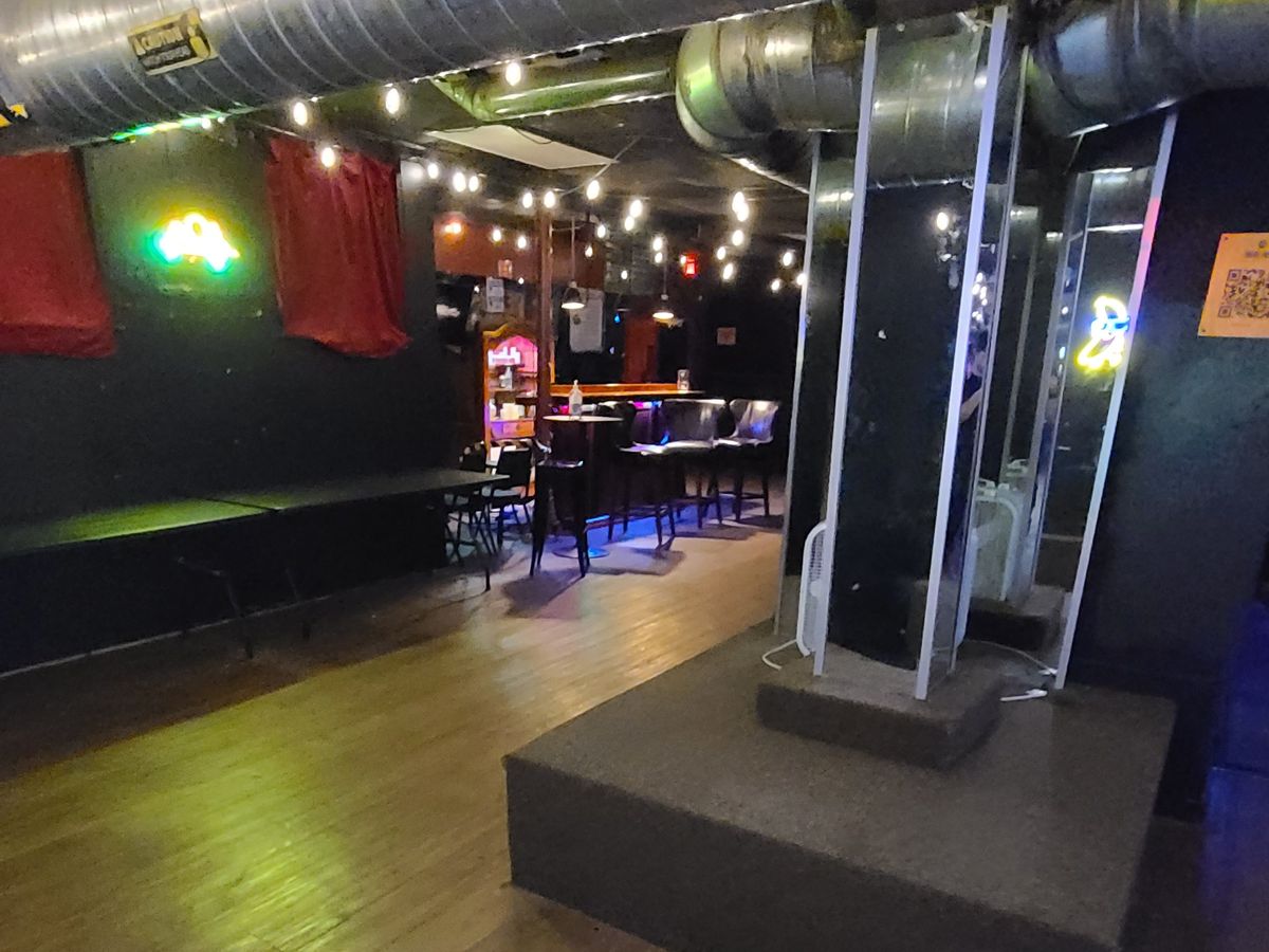 The open downstairs floor and a raised platform, with the bar in the background